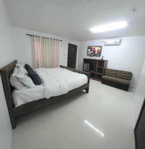 a bedroom with a bed and a television in it at wombats beach resort,hotel, bar and restaurant in Olongapo