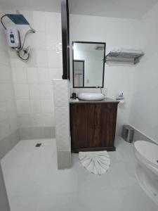 a bathroom with a sink and a mirror at wombats beach resort,hotel, bar and restaurant in Olongapo +9 photos