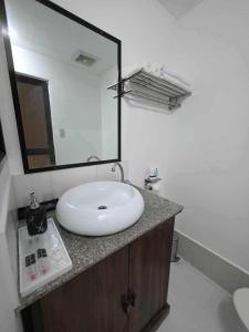 a bathroom with a white sink and a mirror at wombats beach resort,hotel, bar and restaurant in Olongapo