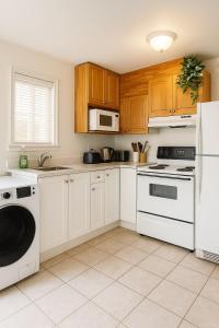 eine Küche mit weißen Geräten und Holzschränken in der Unterkunft Sweet 2-bedrooms house in Vancouver in Vancouver