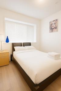 ein Schlafzimmer mit großem Bett und Fenster in der Unterkunft Sweet 2-bedrooms house in Vancouver in Vancouver