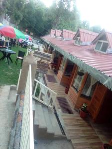 a house with a deck with a table and umbrella at Royal Dutch Resorts and Doll Museum in Mukteswar