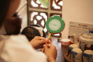 une personne tenant une brosse à dents avec une ventouse verte et blanche dans l'établissement Hue Memories Signature, à Thôn Trường Giang