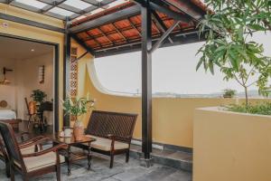un patio avec une table, des chaises et un lit dans l'établissement Hue Memories Signature, à Thôn Trường Giang