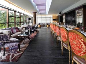 um restaurante com uma fila de cadeiras e um bar em Sofitel Saigon Plaza em Cidade de Ho Chi Minh