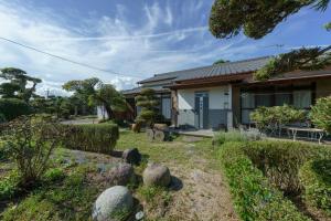 a house with a garden in front of it at ようこそ月の宿へ in Shindembaru
