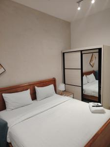 a bedroom with a large white bed and a mirror at Trion Residence Kuala Lumpur by Centrix in Kuala Lumpur