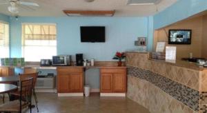 cocina con barra con mesa y TV en Scottish Inns Augusta, en Augusta