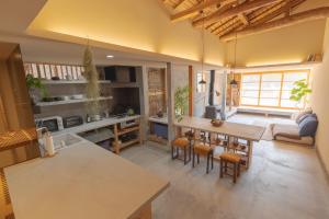 a kitchen and living room with a table and chairs at La toile in Mitoyo