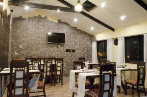 un restaurante con mesas y sillas y TV en la pared en Cusco Bed and Breakfast, en Cusco