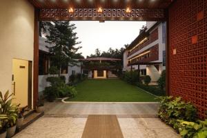 einen Innenhof eines Gebäudes mit grünem Rasen in der Unterkunft Coral Sand Beach Resort By Privy Stays in Nagaon