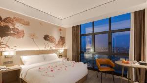 a bedroom with a bed and a table and a window at GRACE Select Hotel (Kunshan Huaqiao International Convention Center) in Xinqiao +225 photos