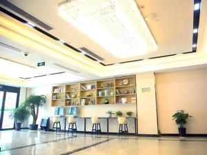 a lobby with stools and shelves with plants at GreenTree Inn Shanghai Fengxian District Xiaotang Metro Station in Xidu
