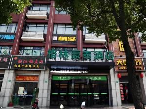 a building with signs on the side of it at GreenTree Inn Shanghai Fengxian District Xiaotang Metro Station in Xidu