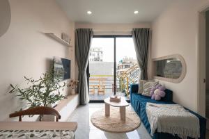 a living room with a blue couch and a window at DKA Balance in Ho Chi Minh City