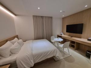 a hotel room with a bed and a television at 인별호텔 in Suncheon