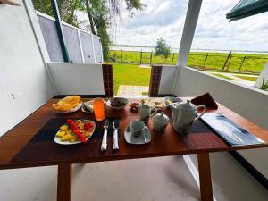 - une table avec petit-déjeuner sur le balcon dans l'établissement Sunrise Lake Resort, à Polonnâruvâ