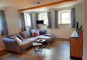 a living room with a couch and two windows at Spilla - Dein Ferien-Zuhause 