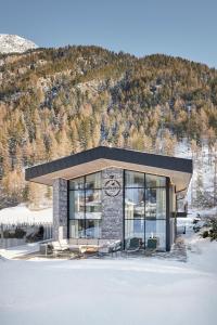 a building with chairs and tables in front of a mountain at Chalet White Pearl by MYALPS in Sölden