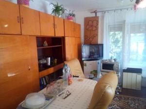 a living room with a table and chairs and a kitchen at Kulcsosház vendégház in Hollóháza