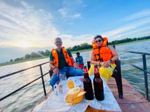 deux personnes portant des gilets de sauvetage assises à une table sur un bateau dans l'établissement Sunrise Lake Resort, à Polonnâruvâ