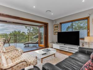 Caddys IslandにあるHillcrest Retreat with River Viewsの薄型テレビとソファのあるリビングルーム