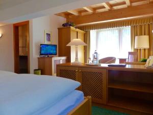1 dormitorio con 1 cama y escritorio con ordenador en Hotel Garni Zerzer, en Serfaus