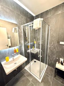 ein Badezimmer mit Dusche und Waschbecken in der Unterkunft apartino - Moderní apartmán v novostavbě - Omezený přístup a stavební ruch do listopadu 2025 - New Building - Limited Access and Construction noise till November 2025 in Komárov + 25 Fotos