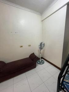 a living room with a couch and a fan at Harmony Transient in Baguio