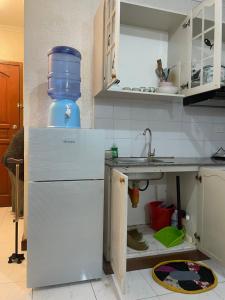 a kitchen with a white refrigerator and a sink at Harmony Transient in Baguio +7 photos
