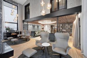 a living room with chairs and tables and bookshelves at Chalet White Pearl by MYALPS in Sölden +33 photos