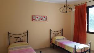 フロリーディアにあるVilla Cristinaのベッドルーム1室(ベッド2台、窓付)