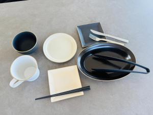 a table with a black plate and two cups and chopsticks at Villa Blanche - Vacation STAY 31400v in Sumoto +8 photos