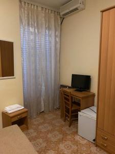 1 dormitorio con escritorio, ordenador y TV en New Hotel Attico, en Chianciano Terme 3 fotos más