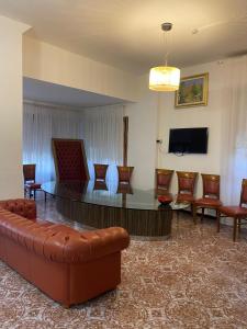 Una sala de estar con un sofá, una mesa y sillas. en New Hotel Attico, en Chianciano Terme