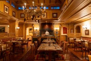 a man standing in a restaurant with tables and chairs at Mont Cervin Palace in Zermatt