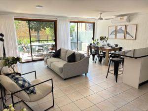 een woonkamer met een bank en een tafel bij Catalina Cove-From Door to Shore in 2 Minutes in Shoal Bay