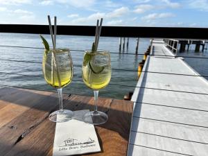twee glazen wijn zittend op een tafel naast het water bij Catalina Cove-From Door to Shore in 2 Minutes in Shoal Bay +10 foto's