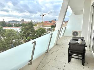 einen Balkon mit einem Schreibtisch und Stadtblick in der Unterkunft apartino - Moderní apartmán v novostavbě - Omezený přístup a stavební ruch do listopadu 2025 - New Building - Limited Access and Construction noise till November 2025 in Komárov