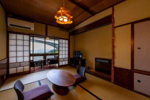 a living room with a wooden table and chairs at Okamotoya in Beppu +89 photos