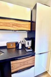 a kitchen with a refrigerator and a coffee maker on a counter at Porschenahe Wohung in Stuttgart