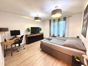 a bedroom with a bed and a desk with a computer at Porschenahe Wohung in Stuttgart +8 photos