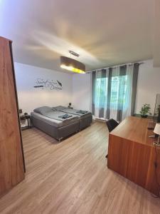 a bedroom with a bed and a desk in a room at Porschenahe Wohung in Stuttgart