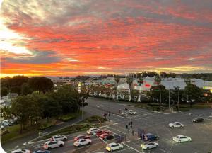 a parking lot with cars in a parking lot with a sunset at Mains Rd 后院的独立田园小屋9 in Brisbane