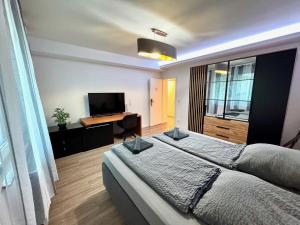 a bedroom with a large bed and a television at Porschenahe Wohung in Stuttgart
