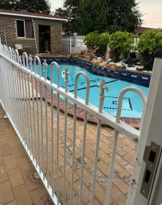 a white fence next to a swimming pool at Mains Rd 后院的独立田园小屋9 in Brisbane