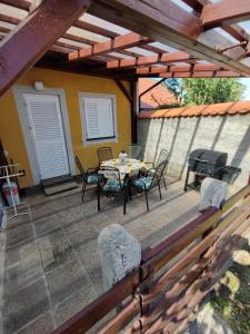 un patio avec une table, des chaises et un barbecue dans l'établissement Apartment by MICHELLE, à Čatež ob Savi