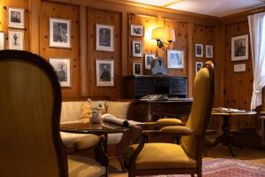 a room with a table and chairs and pictures on the walls at Monte Rosa Boutique Hotel in Zermatt