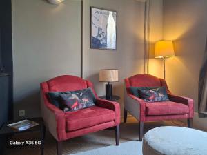 2 sillas rojas y una lámpara en una habitación en The Cozy 42 stylish apartment, en Carcassonne