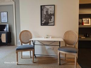 una mesa con dos sillas y una mesa con una mesa y dos sillas en The Cozy 42 stylish apartment, en Carcassonne